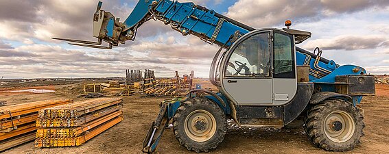 Ein Teleskoplader mit einem mobilen Wiegesystem von PFREUNDT im Arbeitsprozess auf einer Außenfläche